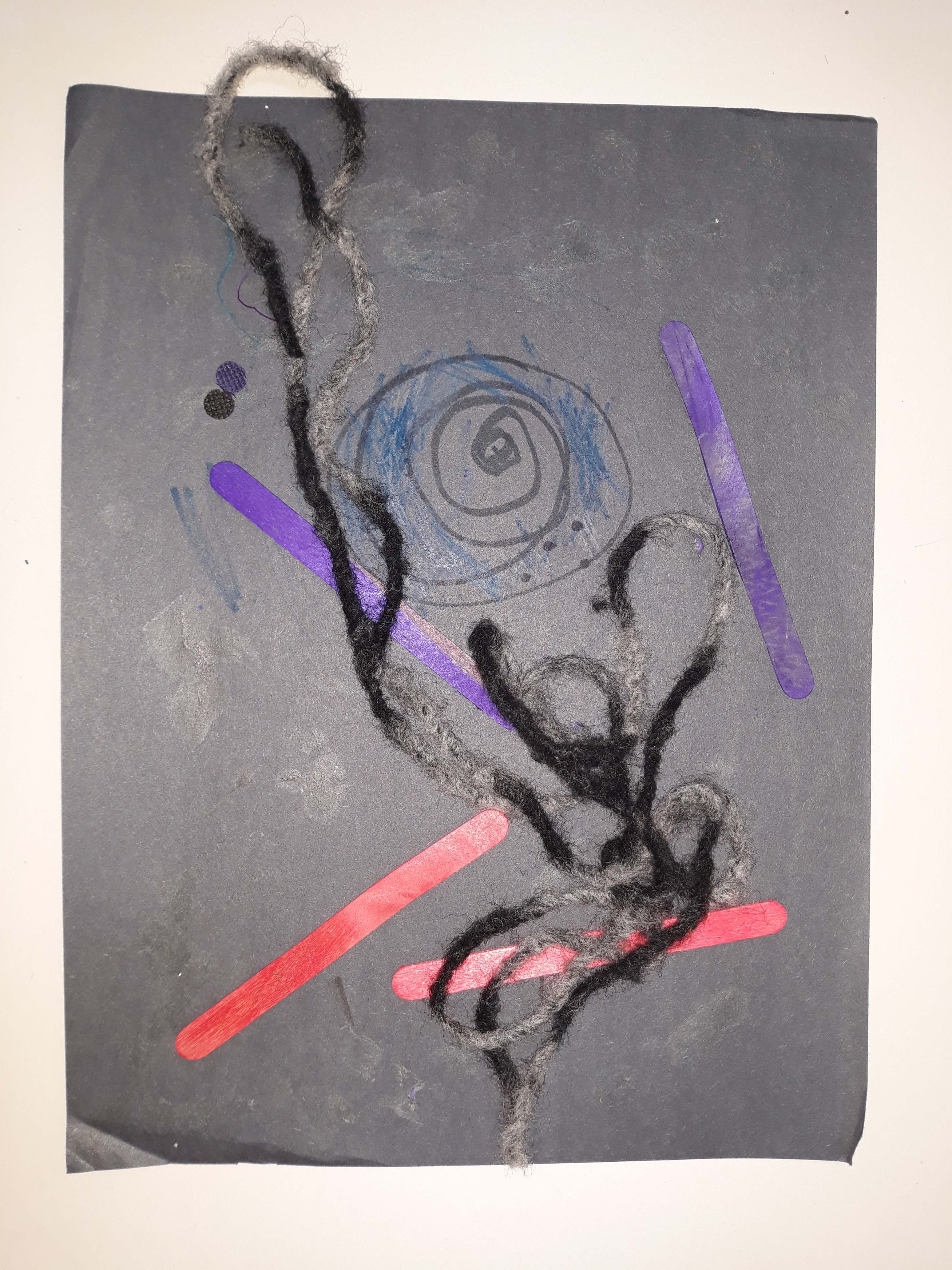 Popsicle sticks, yarn, and markers on black paper in this Space Collage depict what it would be like to travel through a black hole. 